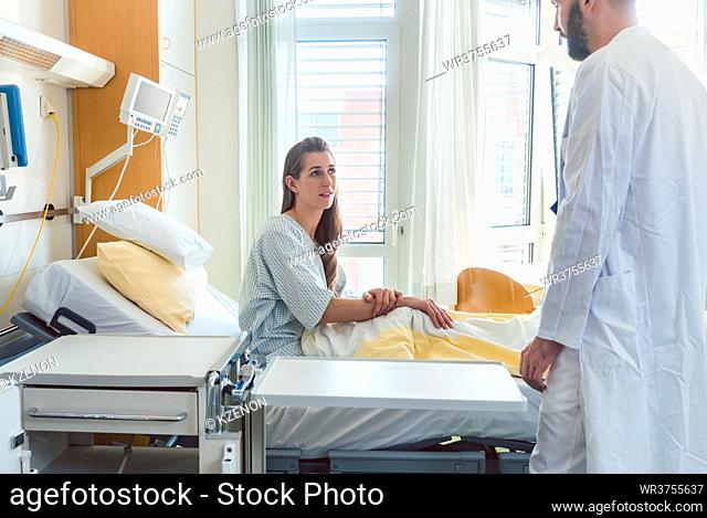 Patient waiting in hospital bed for doctor to see her during ward round