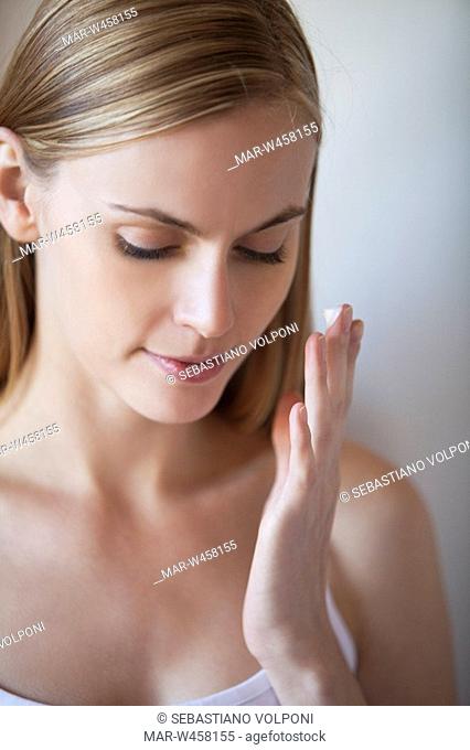 donna si applica la crema per il viso