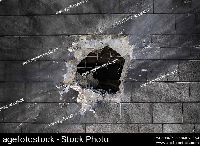 14 May 2021, Israel, Ashkelon: Damages are seen in a wall of a house that was hit by a rocket fired from the Gaza Strip towards Israel amid the escalating...