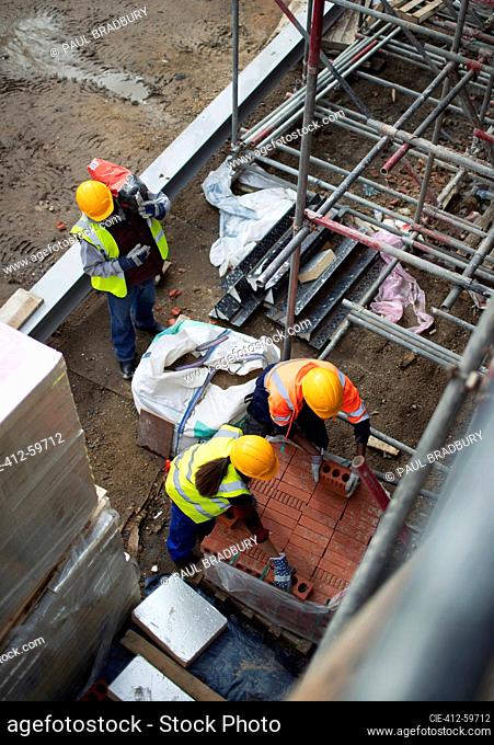 Construction workers with bricks at construction site