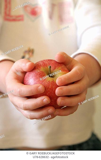Young child offering apple