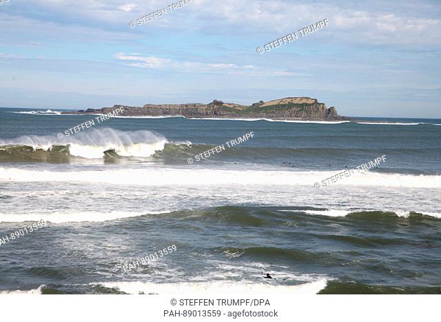 Surfers can be seen in front of the coast of Mundaka, Spain, 1 March 2017. In the background is the uninhabited island Izaro