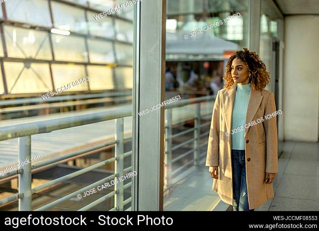Thoughtful woman looking through window at station
