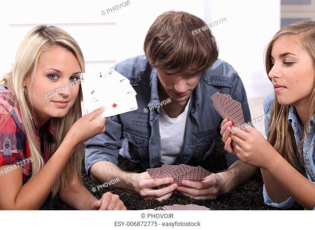Three teenagers playing cards