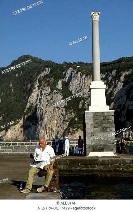 MAN READS NEWSPAPER AT DOCK; MARINA GRANDE, ISLAND OF CAPRI, ITALY; 17/09/2011