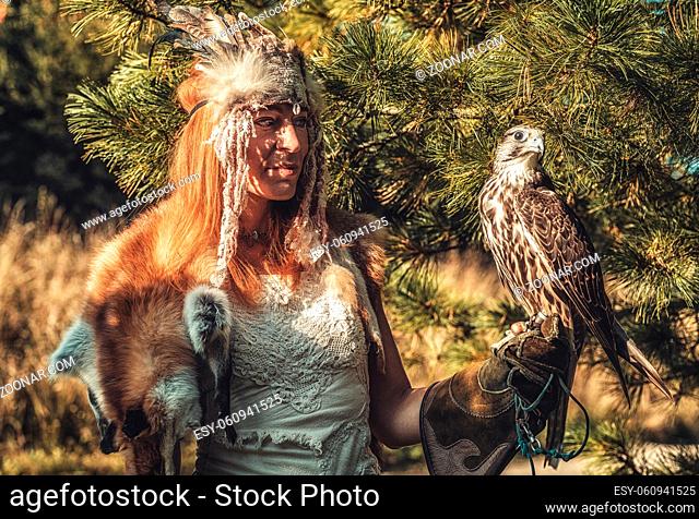 beautiful shamanic woman with eagle in the nature