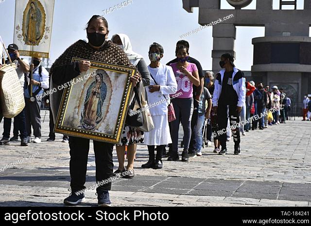 MEXICO CITY, MEXICO - DECEMBER 8: A Faithful holds a picture of the Virgin of Guadalupe while visit the Basilica of Guadalupe church as part of pilgrimage to...