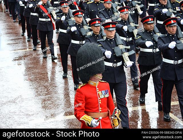 06 May 2023, Great Britain, London: A member of the royal bodyguard and members of the armed forces march in procession to Buckingham Palace after the...