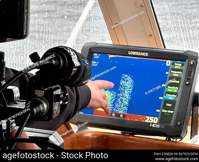26 August 2023, Great Britain, Drumnadrochit: Skipper Ali Matheson points to a sonar image of Loch Ness. In Scotland, what is believed to be the largest search...