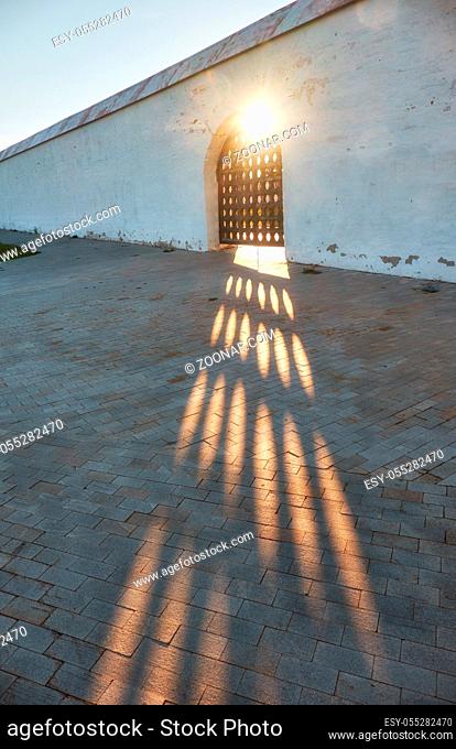 At sunset, sun rays break through the lattice doors of the wall of Tobolsk Kremlin. Tobolsk. Russia