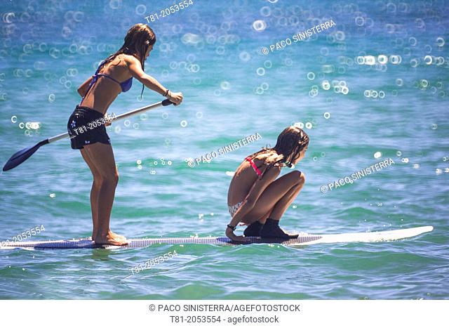 Girls on surfboard paddling in the Mediterranean Sea, Benicassim, Castellon province, Comunidad Valenciana, Spain