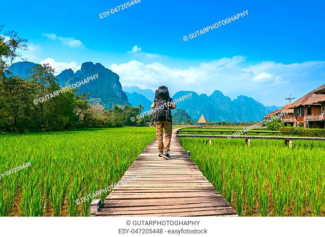 Tourism with backpack walking on wooden path, Vang vieng in Laos