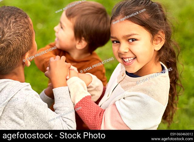 happy children playing and stacking hands at park