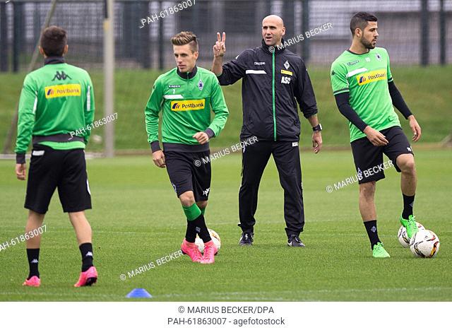 Moenchengladbach's caretaker coach Andre Schubert (3-L) instructs his players including Patrick Herrmann (2-L) and Alvaro Dominguez (R) during a training...