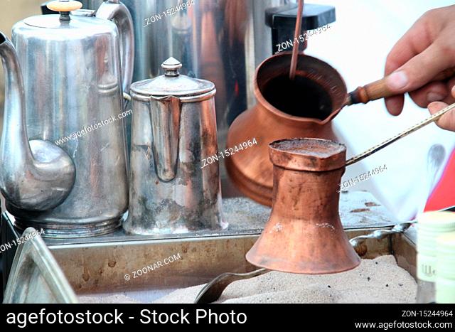 Old coffee pot, traditional turkish coffee being prepared in hot sand