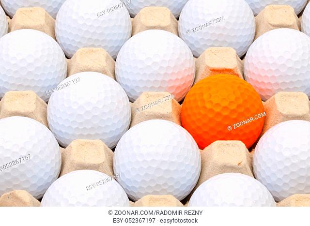 White and orange golf balls in the box for eggs