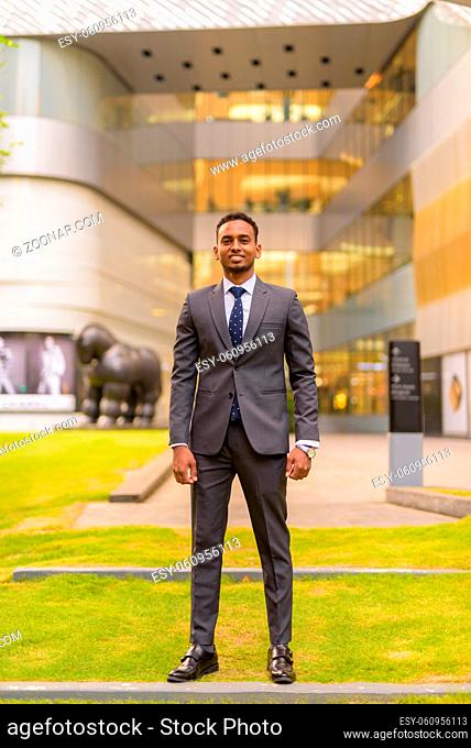 Portrait of handsome African businessman outdoors wearing suit