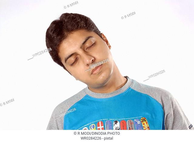 South Asian Indian man doing exercise closing eyes turn head to right side MR 628