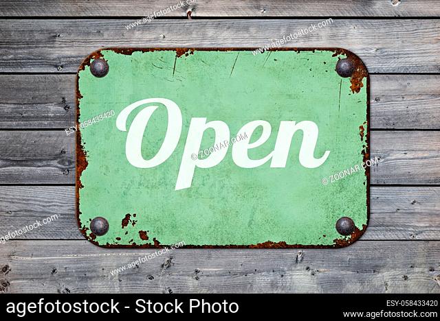 Vintage tin sign on a wooden background - Open