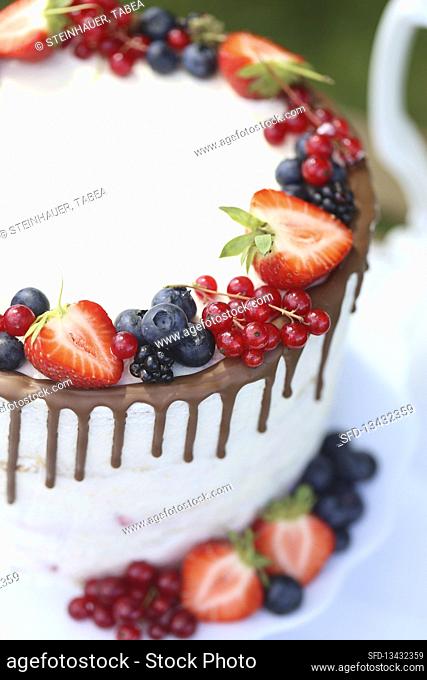 White drip cake with fresh berries