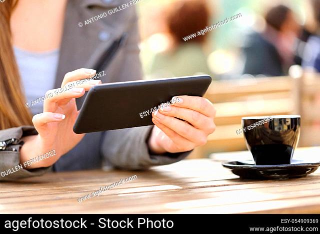 Close up of woman hands watching videos on her smart phone on a cafe terrace