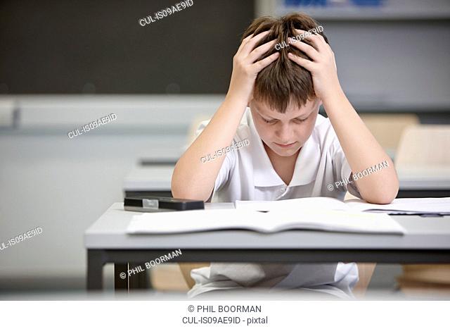 Schoolboy struggling in educational exam