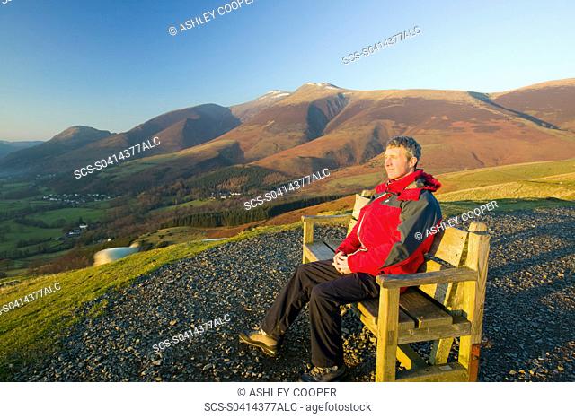A man enjoying the view from Latrigg above Keswick Lake District UK