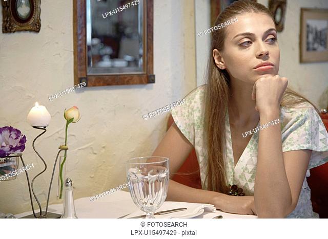 Bored woman sitting at dining table