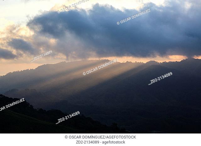 Sunrise and light beams over forested hillsides. Doi Pha Hom Pok National Park. Thailand