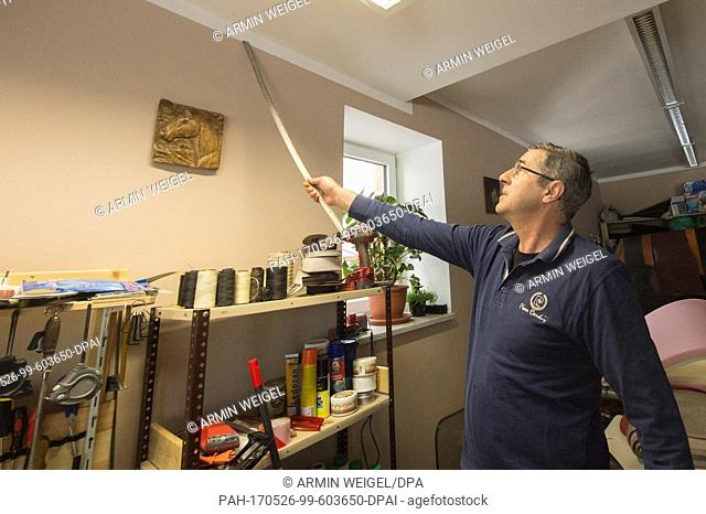 Saddler Vasile Stratulat demonstrates how high the water went in his shop in Simbach am Inn, Germany, 18 May 2017. One year ago a massive flood destroyed...