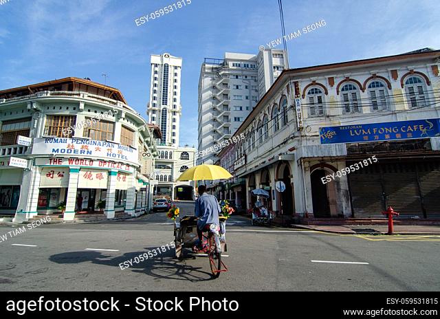 Georgetown, Penang/Malaysia - Jul 02 2016: A trishaw driver at the junction of street in morning