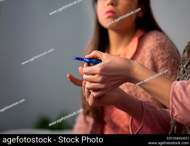Close up of woman hands palying spinner. Little girl looking at her