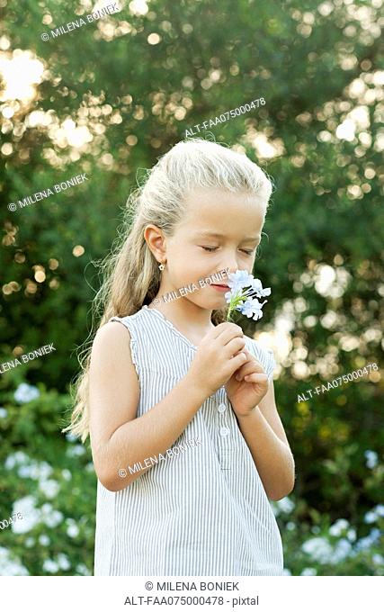 Girl smelling flowers, eyes closed