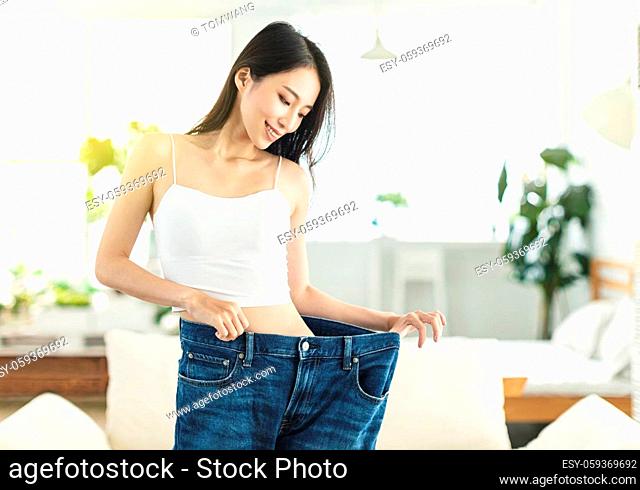 young woman succeeded in losing weight. She wore large-size jeans a long time ago, showed her figure very confidently, and was in happy mood