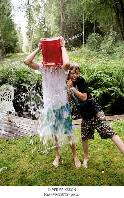Boys playing with water in a garden a summer day, Sweden
