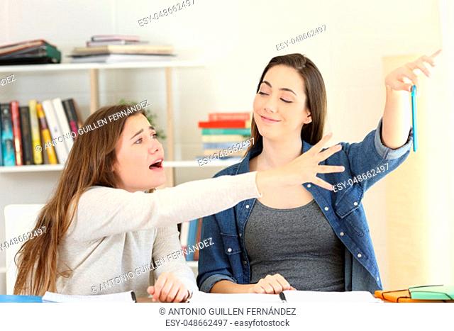 Two students fighting for a mobile phone at home