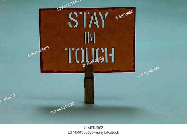 Text sign showing Stay In Touch. Conceptual photo Keep Connected thru Phone Letters Visit Email Social Media Clothespin holding orange paper important...