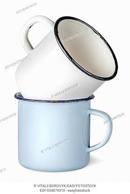 Two old enameled mugs on each other isolated on white background