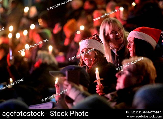 22 December 2022, Mecklenburg-Western Pomerania, Rostock: people take part in Christmas caroling at the Ostseestadion. At the first caroling, more than 10