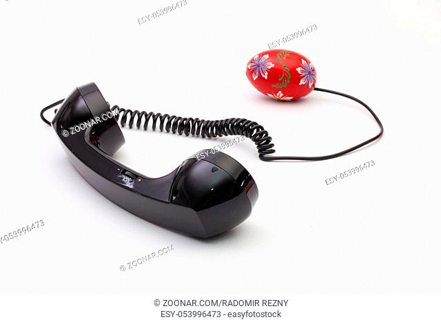 Old phone reciever and cord connection with Easter eggs. Easter hotline concept