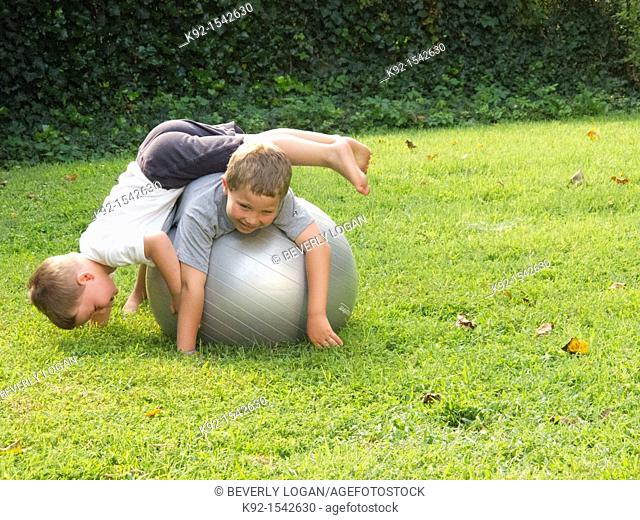 Boys playing on an exercise ball