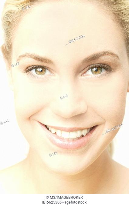 Young blonde woman smiles, close-up, high-key lighting