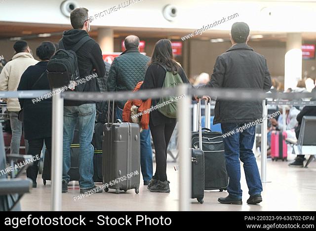 23 March 2022, Hamburg: Numerous passengers stand at a check-in counter in Terminal 1 of the airport. After the warning strike at Hamburg Airport