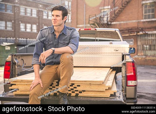 Caucasian man sitting on truck bed