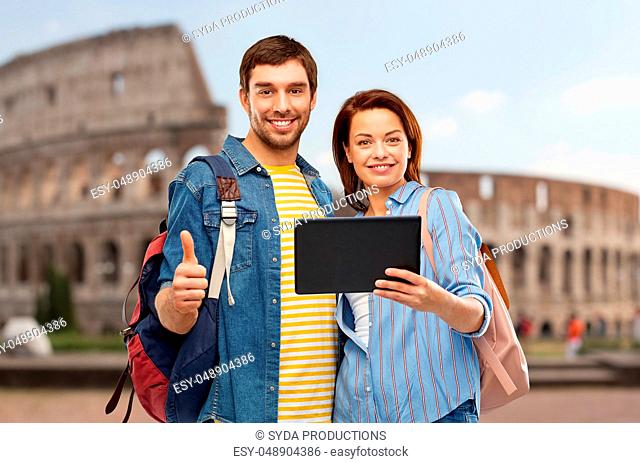 happy couple of tourists with tablet computer