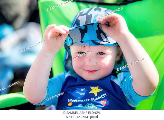 Boy wearing a sun hat and uv clothing