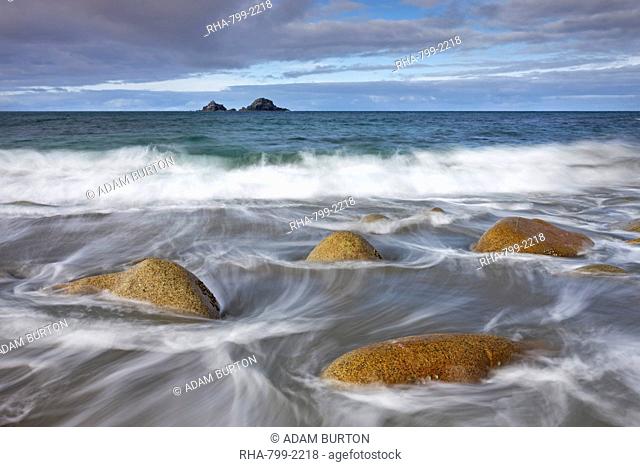 Waves swirl around rocks on Porth Nanven beach, Cornwall, England, United Kingdom, Europe