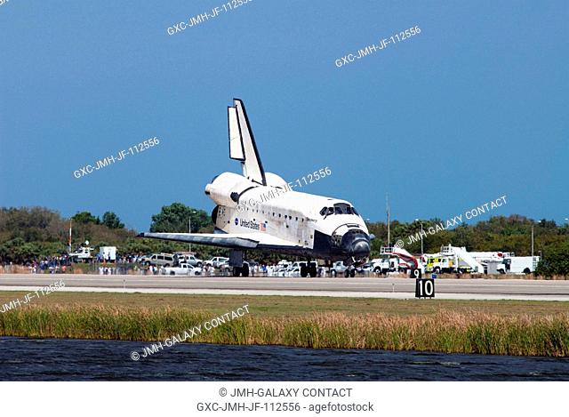 A landing convoy of safety and emergency vehicles meet space shuttle Discovery on Runway 15 at the Shuttle Landing Facility at NASA's Kennedy Space Center in...