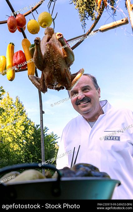 PRODUCTION - 15 September 2023, Rhineland-Palatinate, Bad Kreuznach: Johann Lafer, TV chef and book author, stands by an open wood-burning oven in his garden in...