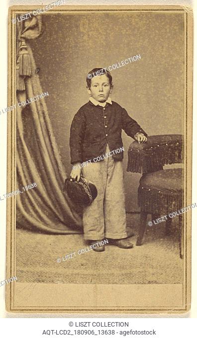 little boy standing, holding his cap, with hand on chair back with tassels; H. Jaeger & Company; 1865 - 1875; Albumen silver print
